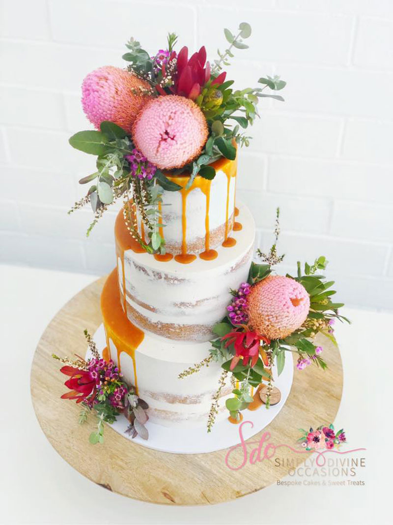 Semi-Naked Wedding Cake with drips and vibrant wildflowers.