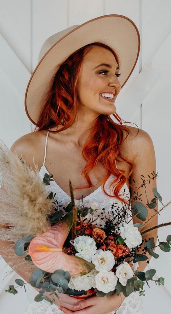 Bride in hat holding a desert inspired Native flower bouquet.