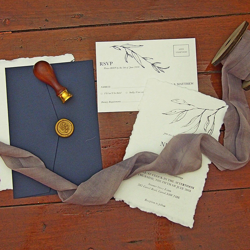 Wedding invitations showing torn edge invitations and wax seals.