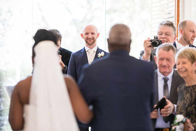 Guests trying to take photos of couple during wedding ceremony.