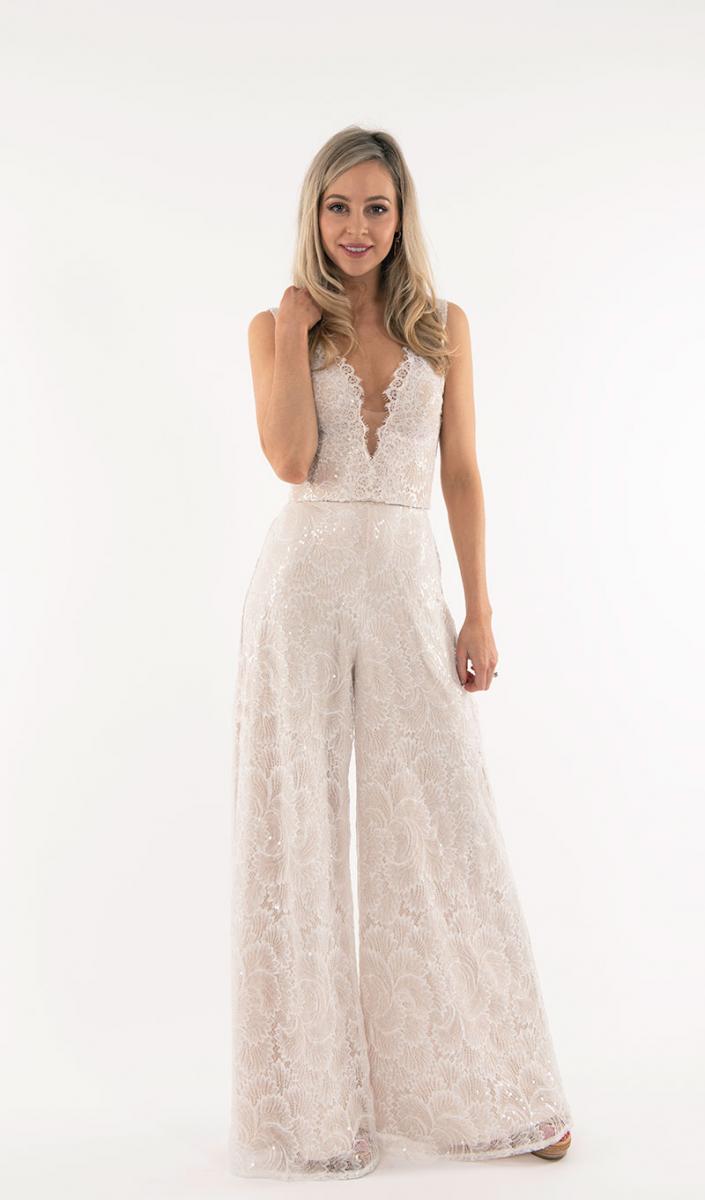 Model wearing lace bridal pantsuit from Q'Nique Exquisite Bridal Wear.