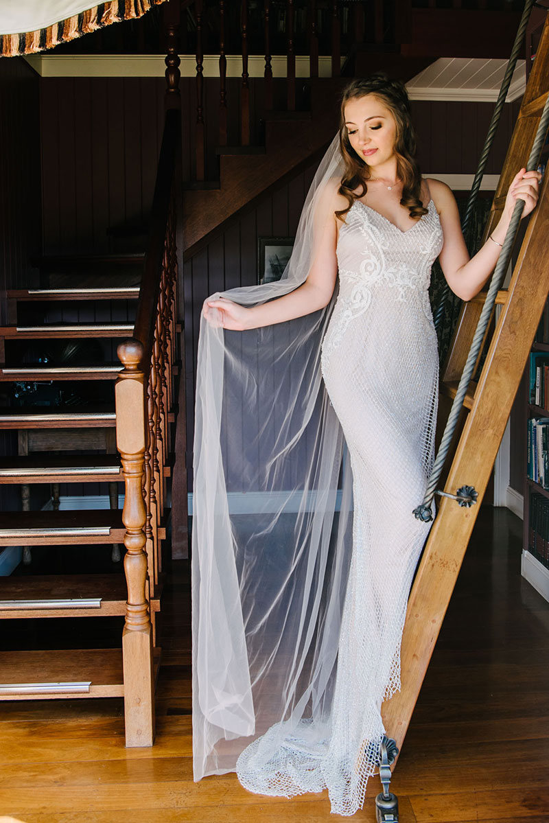 Bride standing on ladder in boho inspired wedding gown.