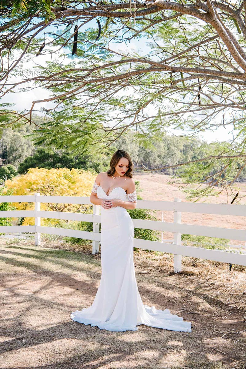 Bride standing outside wearing a strapless wedding gown.