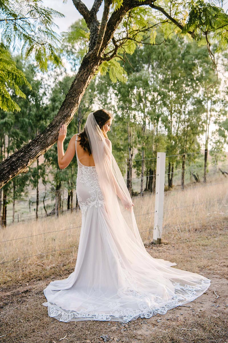 Back of a unique wedding gown shown by bride.