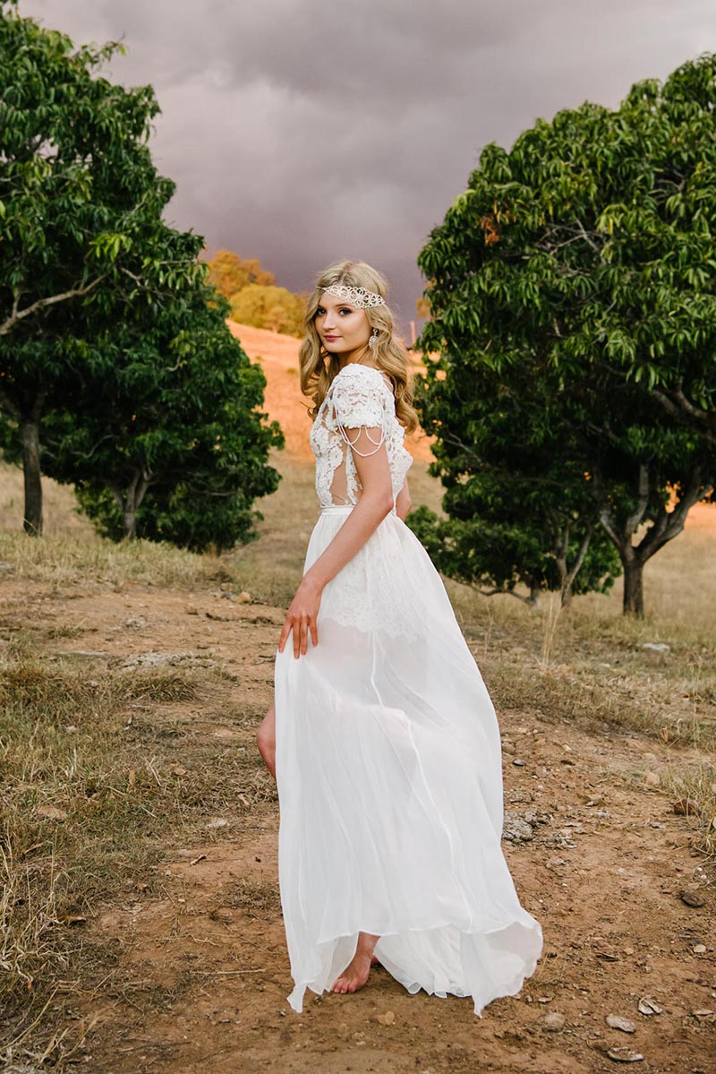 Bride outside wearing a boho lace bodysuit and sheer skirt.