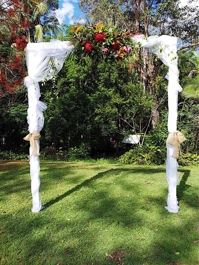 Wedding arch flowers on a white organza arbour.