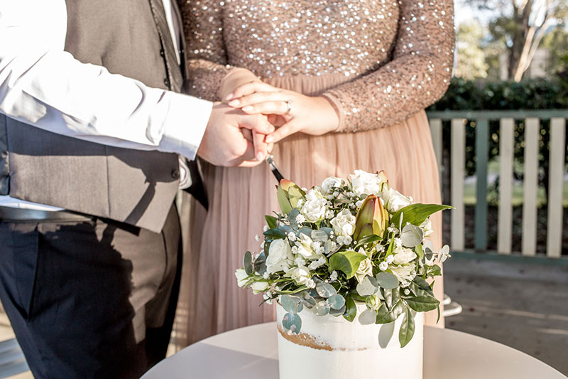 Bride and Groom holding a knife together to cut their wedding cake