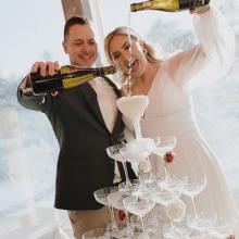Bride and Groom enjoying their Champagne Tower from Rosa Bubbles Champage Towers.