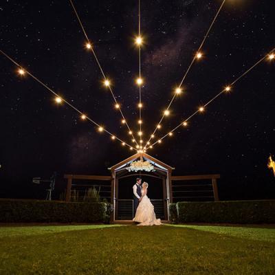 Bride and groom at night with lights at Flaxton Gardens.