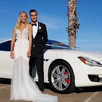 Bride and Groom standing in front of a Maserati.