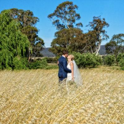 Bride and Groom hug each other in a field.