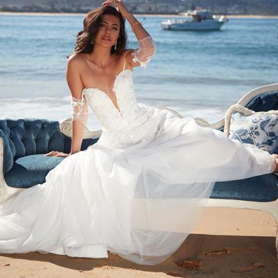 Angelina bridal gown by Sarah Joseph Couture on model sitting on a lounge on the beach.