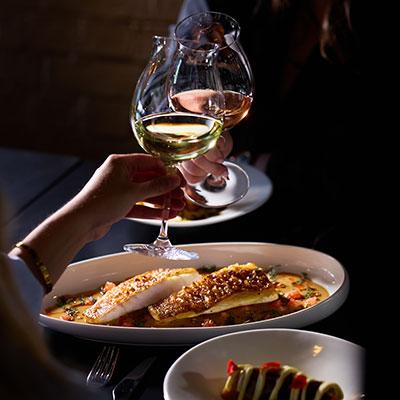 Couple enjoying dinner and a glass of wine at Attimi by Dario Manca